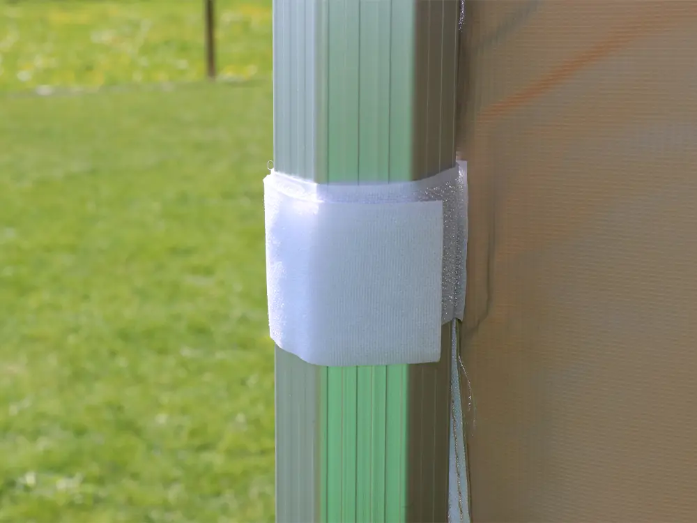 U bevestigt een Solid 50 zijwand met klittenband aan het frame. U ritst de zijwanden onderling aan elkaar.